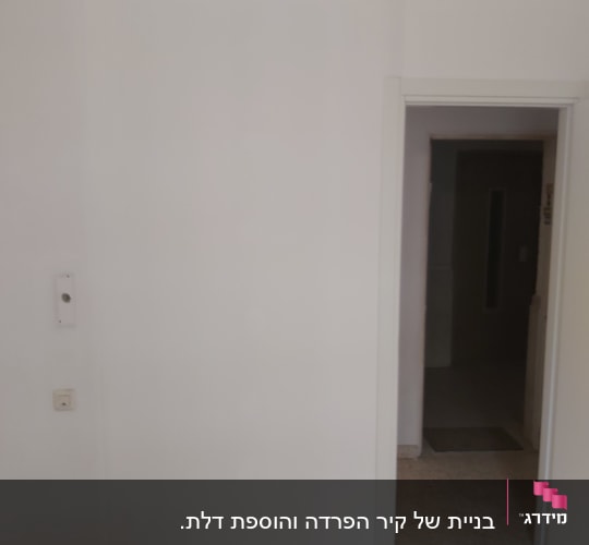 קיר גבס לבן עם דלת פתוחה ורצפת עץ